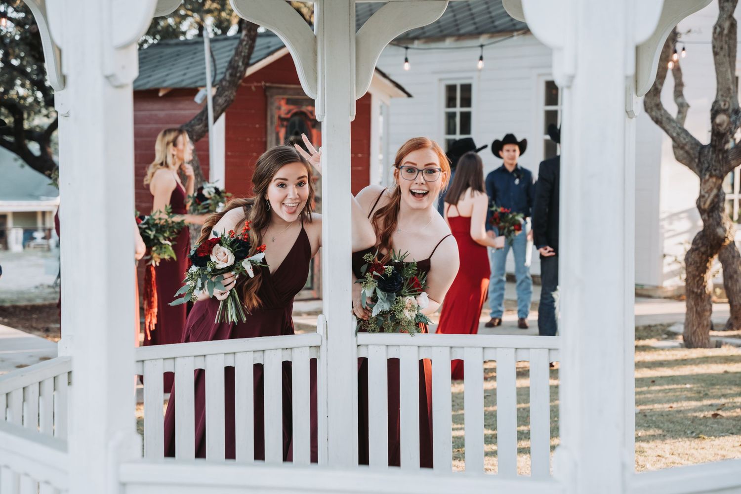Attendants wave from a white gazebo during a wedding celebration.