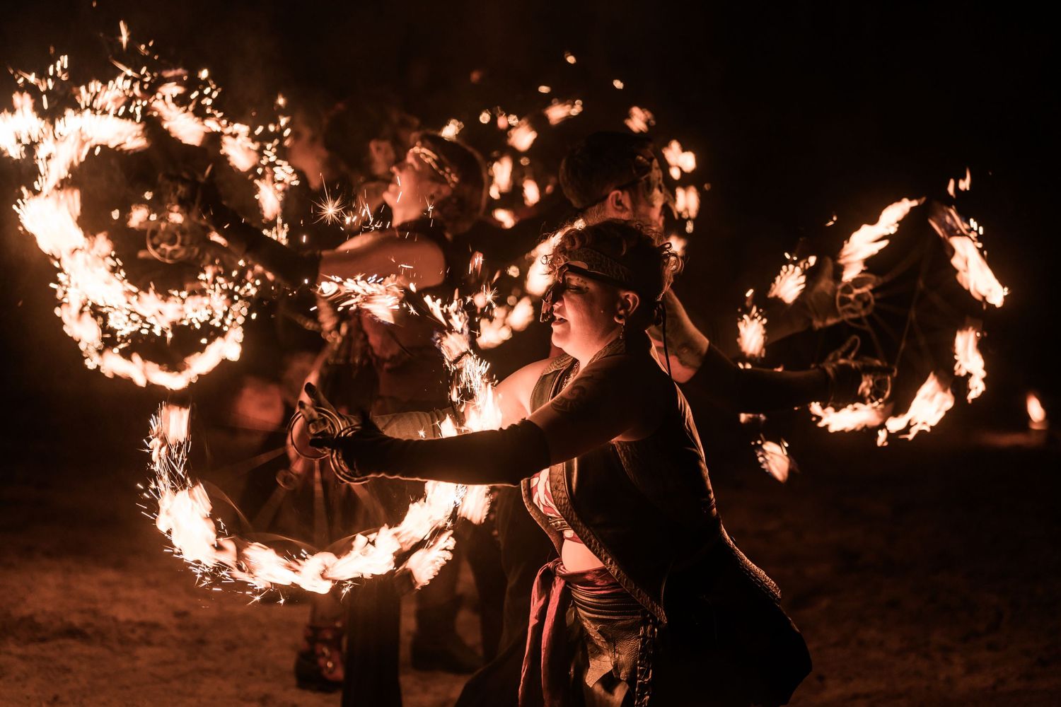 Performer creates mesmerizing circles of fire during a nighttime show.