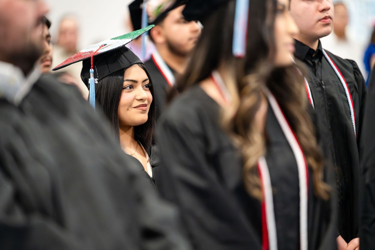 Graduate standing among peers during commencement ceremony.
