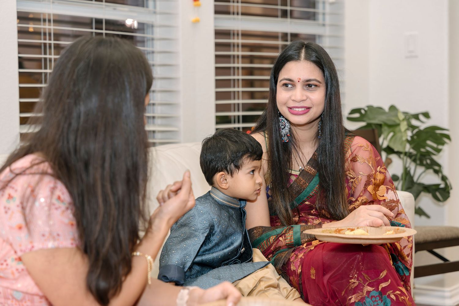 Family enjoying a meal together at home with traditional Indian dishes.