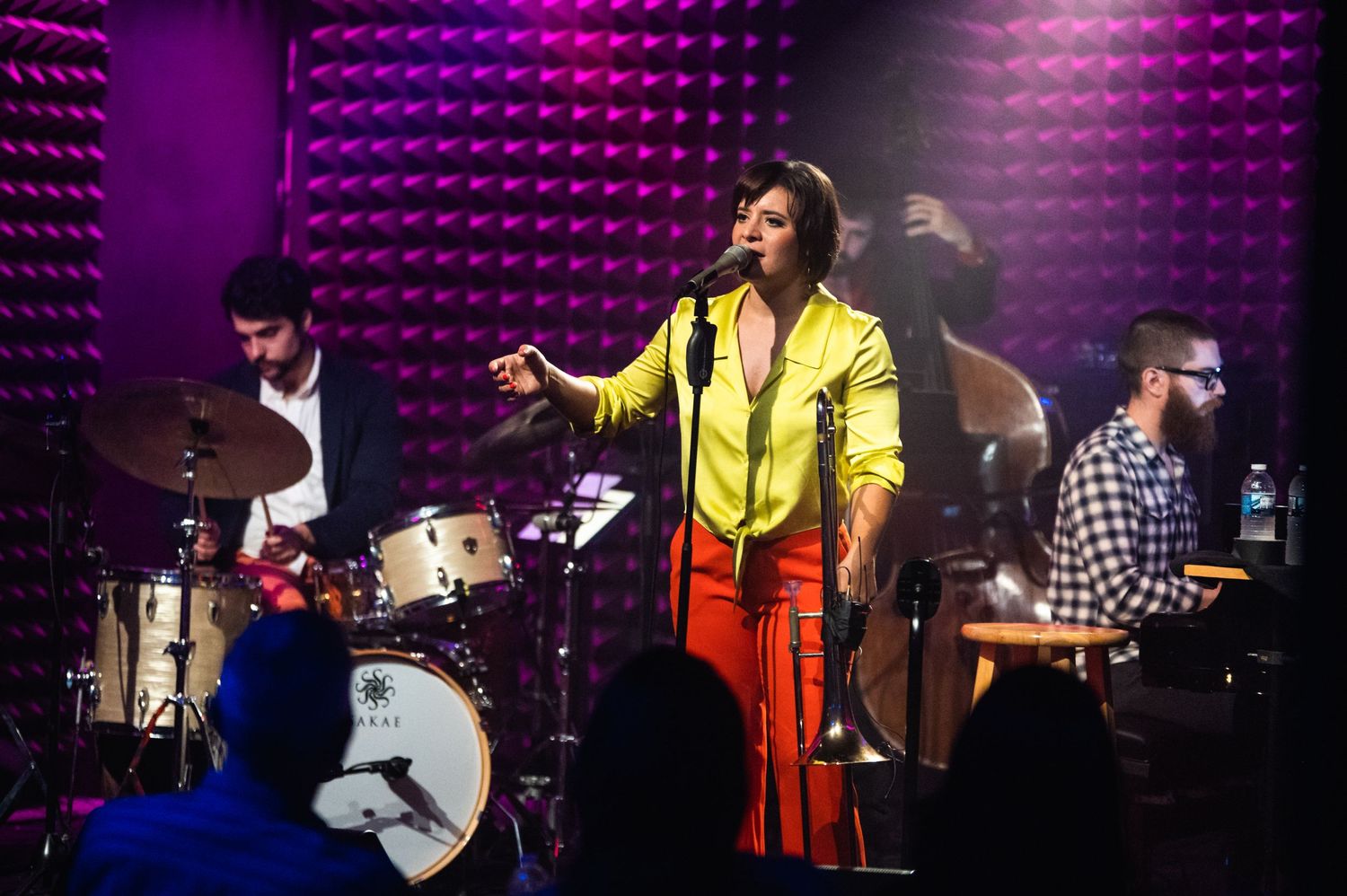 A full band performs on stage at Parker Jazz Club with vibrant purple lighting.