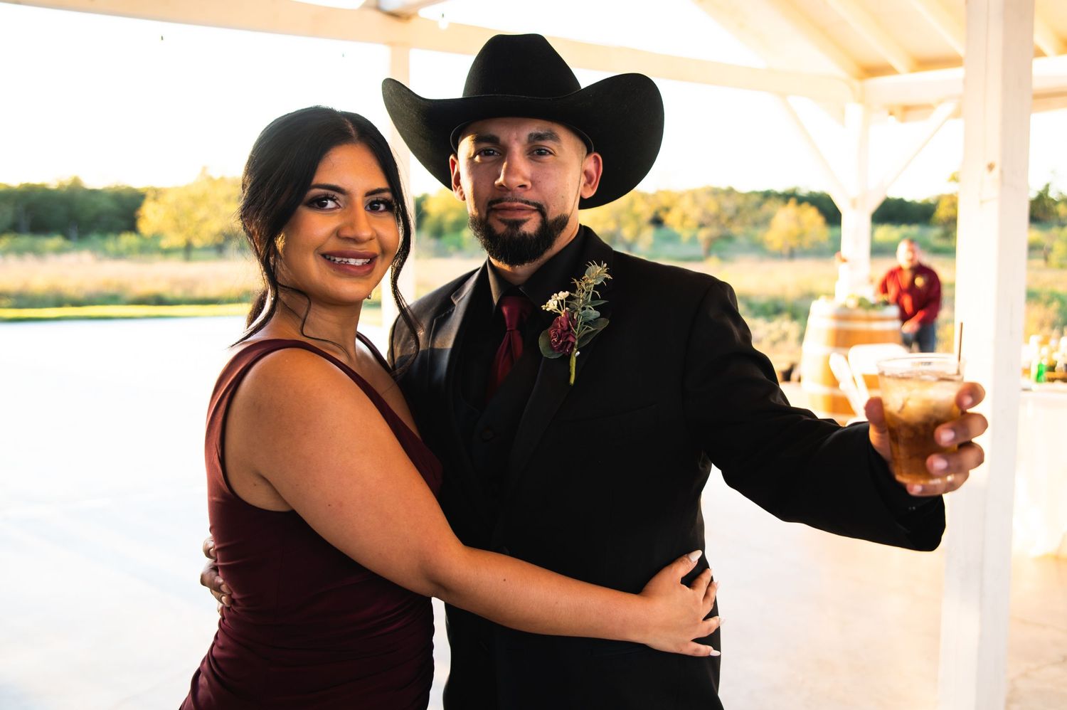 A couple in western attire share a moment at their reception venue.