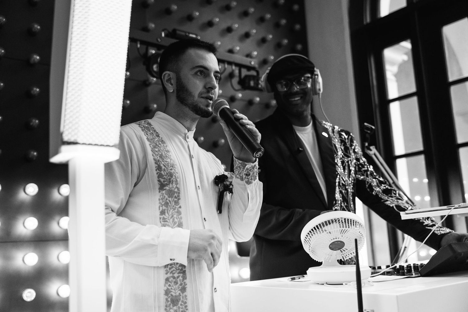 Musicians performing at elegant wedding reception with stage lighting.