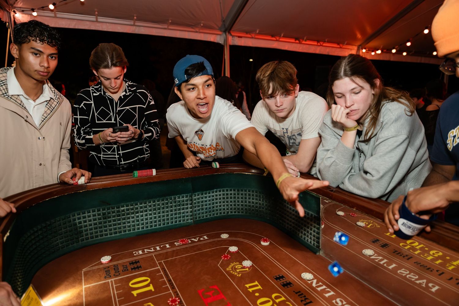 Group of friends enjoying a competitive game of pool at a dimly lit bar.