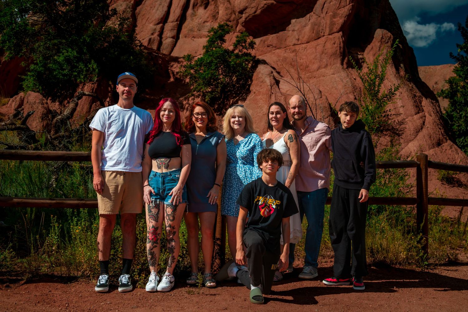 Group posing together on a scenic path with dramatic red rock formations at Garden of the Gods in Colorado.