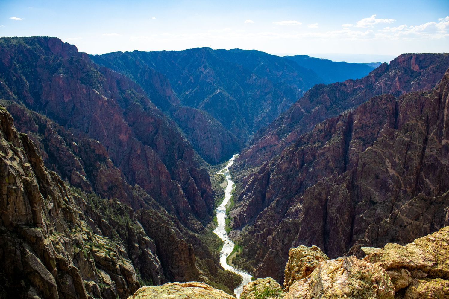 Sweeping vista of Black Canyon showing dramatic depth and winding river path from high viewpoint.