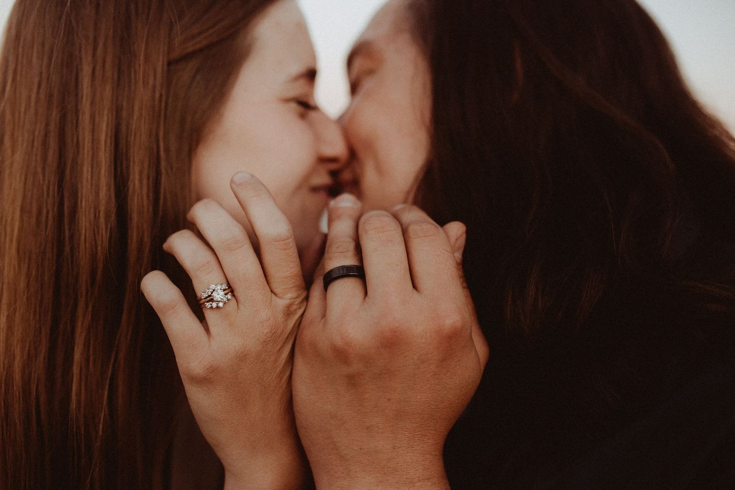 A tender moment captured in silhouette as two people share a romantic kiss with soft lighting.