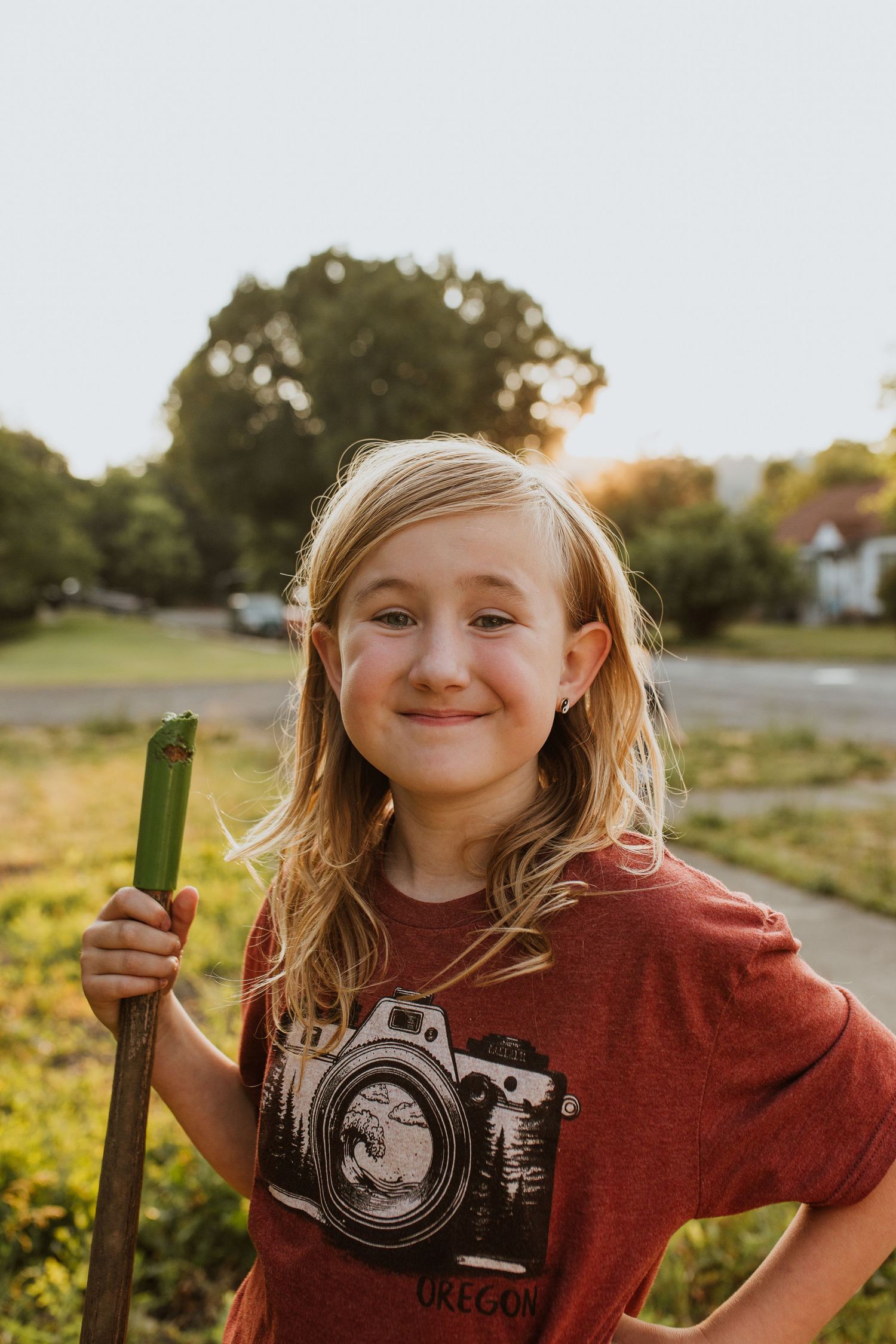 Child in red t-shirt  playing outside during golden hour sunset.