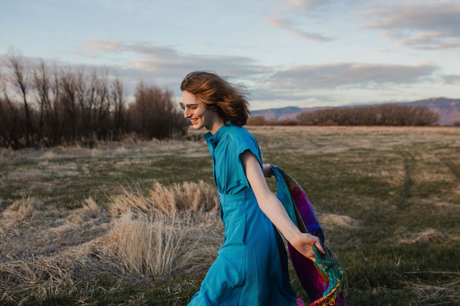 Three landscape photos show a person in a flowing bright turquoise dress walking through a golden autumn field at sunset.