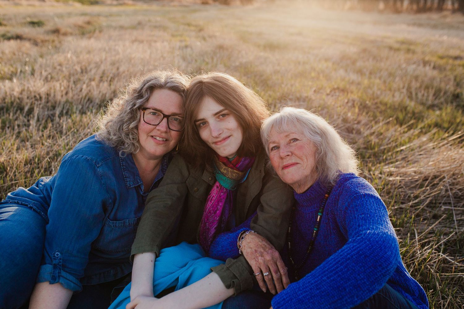 People enjoying a warm sunset in a grassy field during a summer evening photo session.
