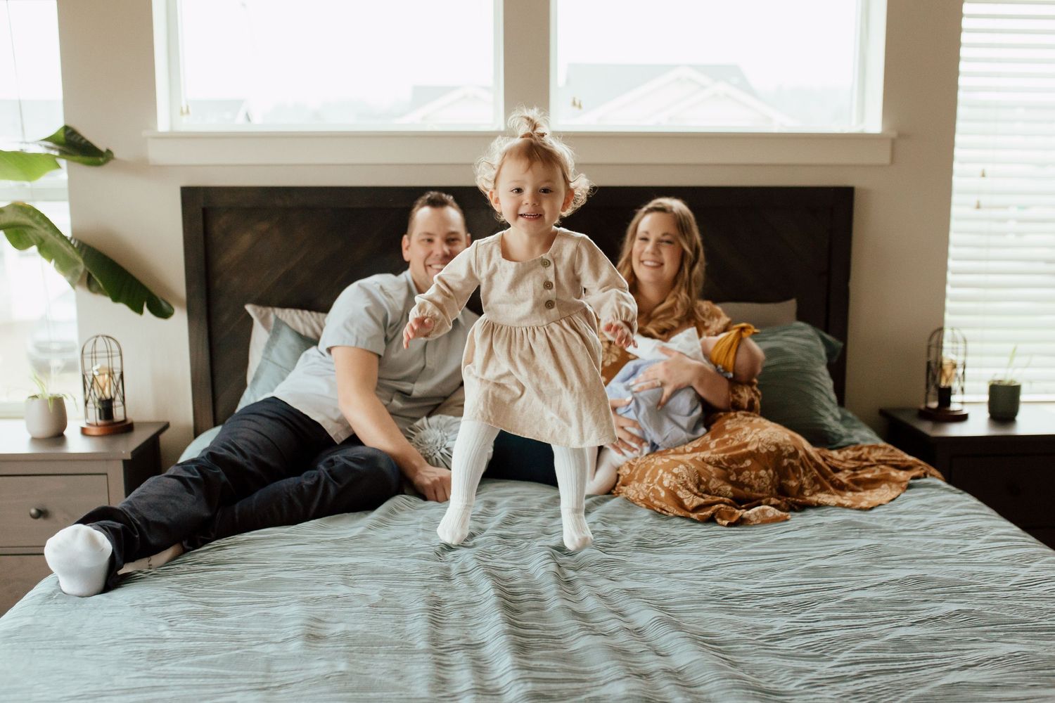 Family snuggling together on bed while enjoying a relaxed morning at home.
