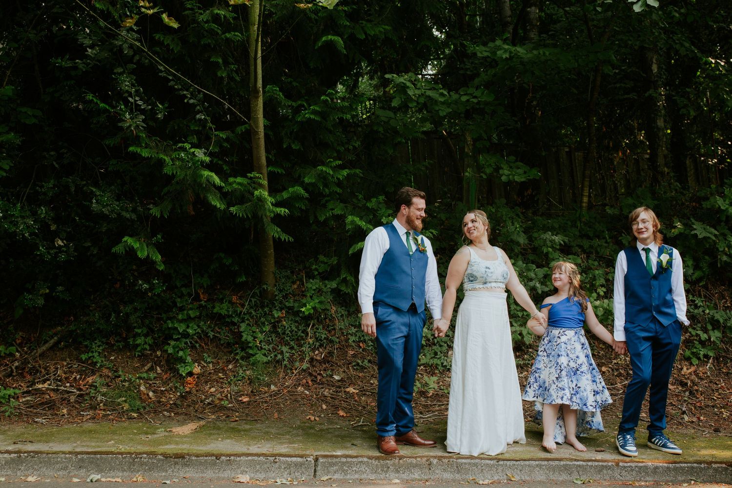 A group gathered outdoors in blue and white attire walking together through a wooded park area.