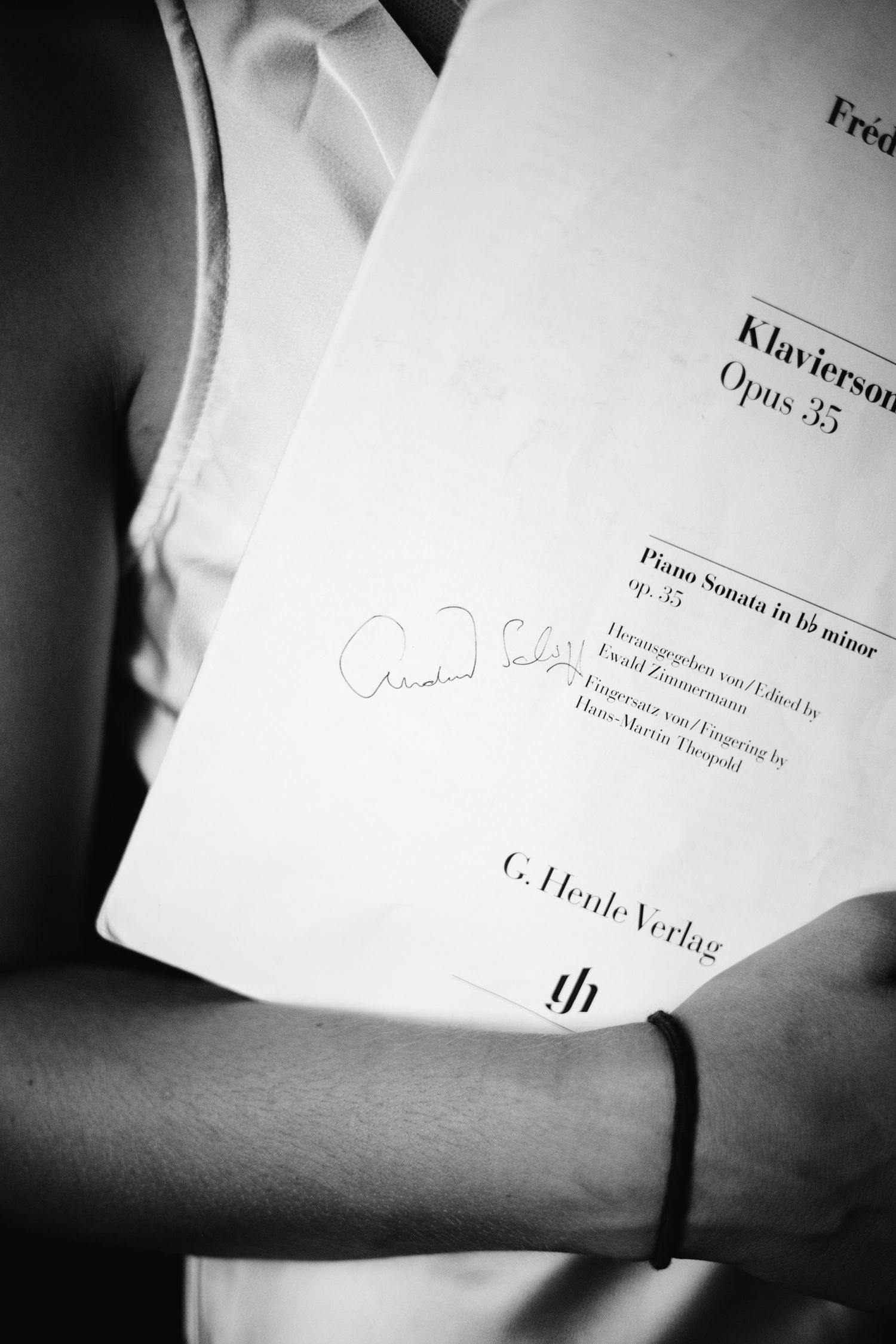 Black and white photo of person holding Chopin Piano Sonata Opus 35 sheet music published by G. Henle Verlag.
