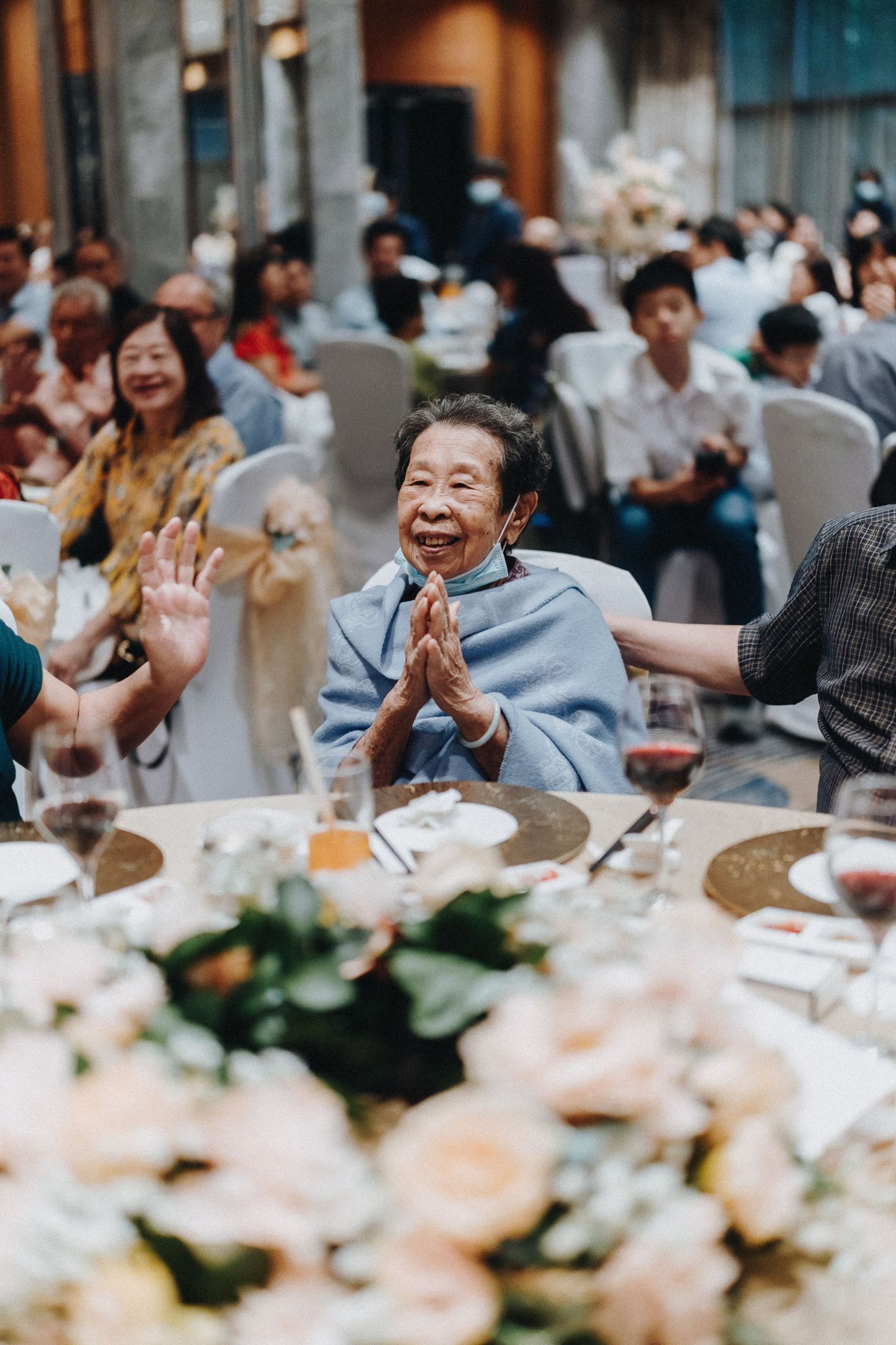 Wedding reception guests celebrating joyfully at decorated banquet tables.