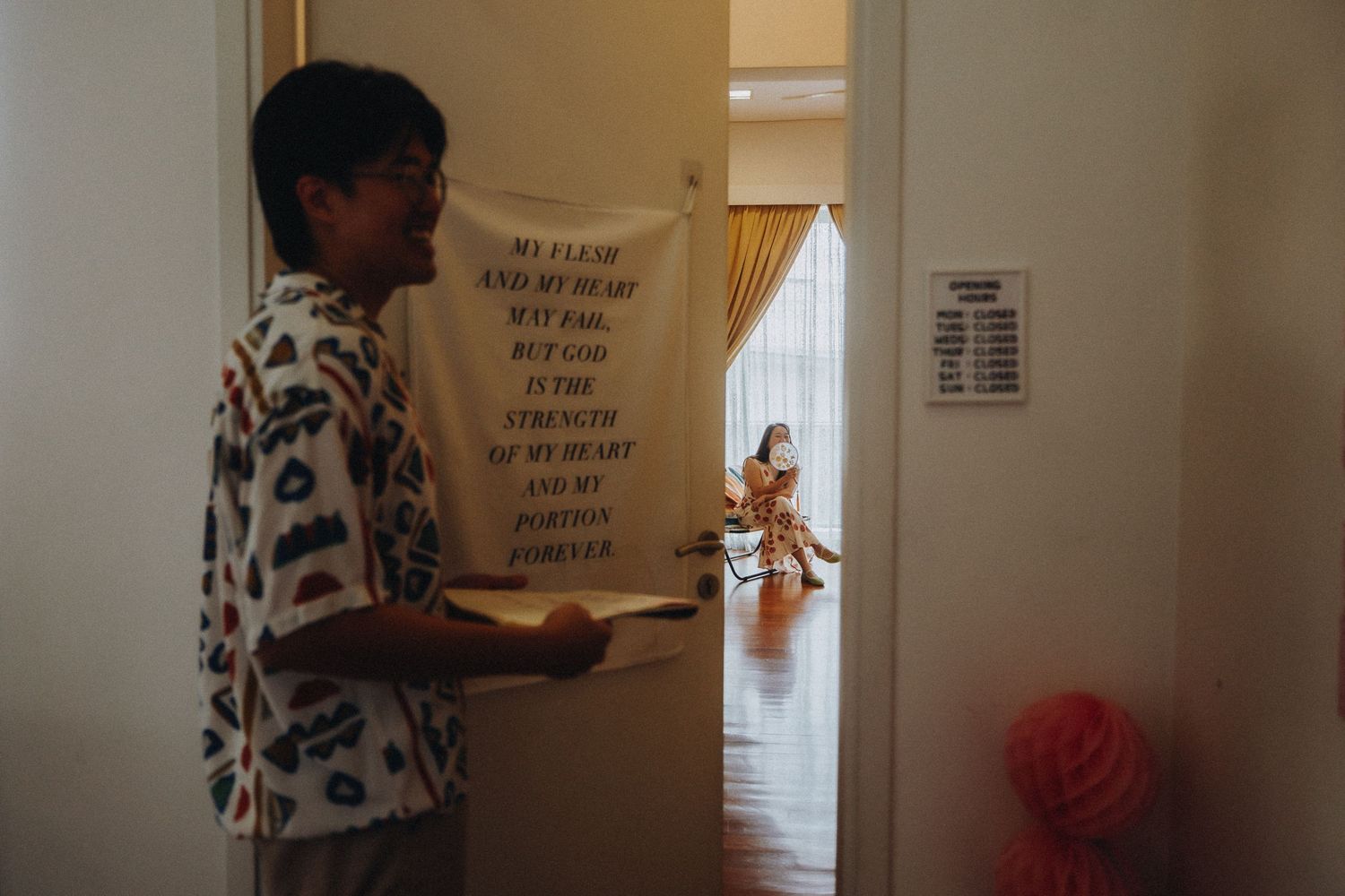 A guest holding a sign while standing in a hallway during a special event.