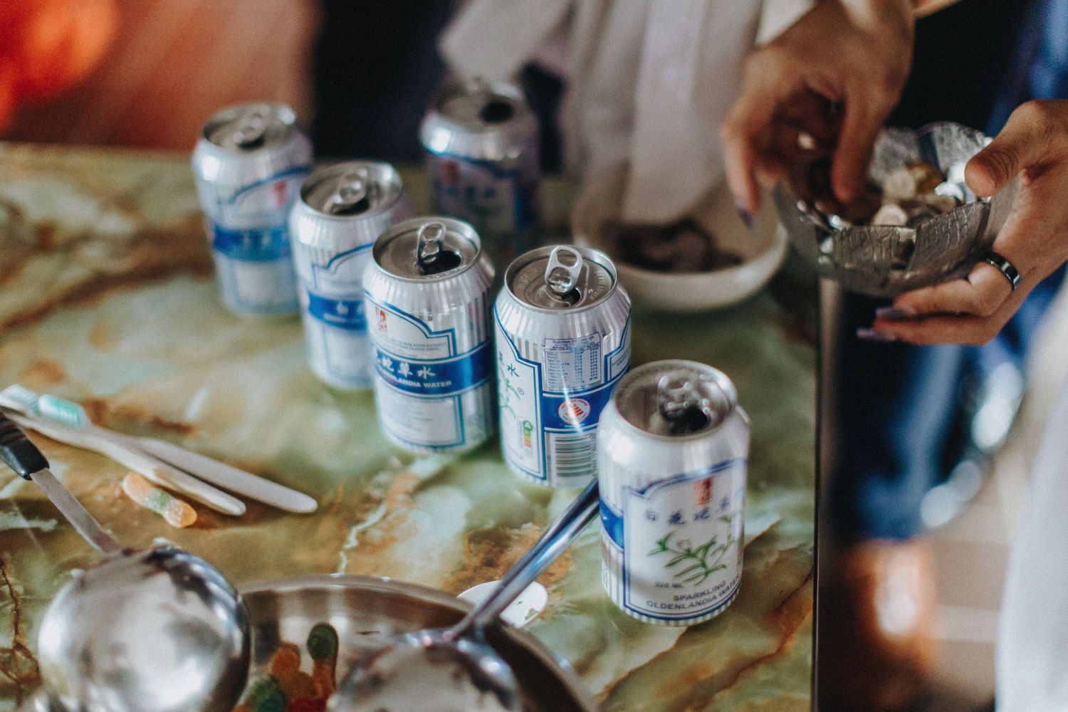 Paint cans, brushes, and art supplies are scattered on a messy work surface during a creative project.