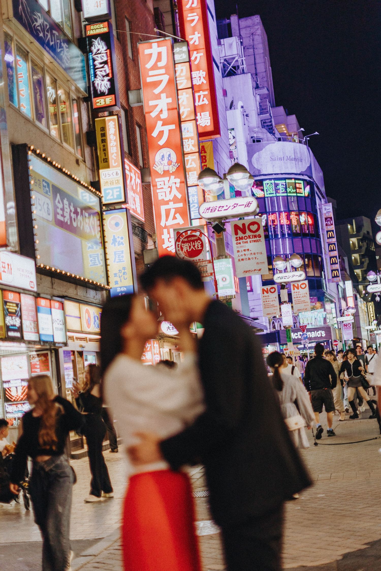 Colorful neon signs and billboards light up a busy shopping district at night in Japan.
