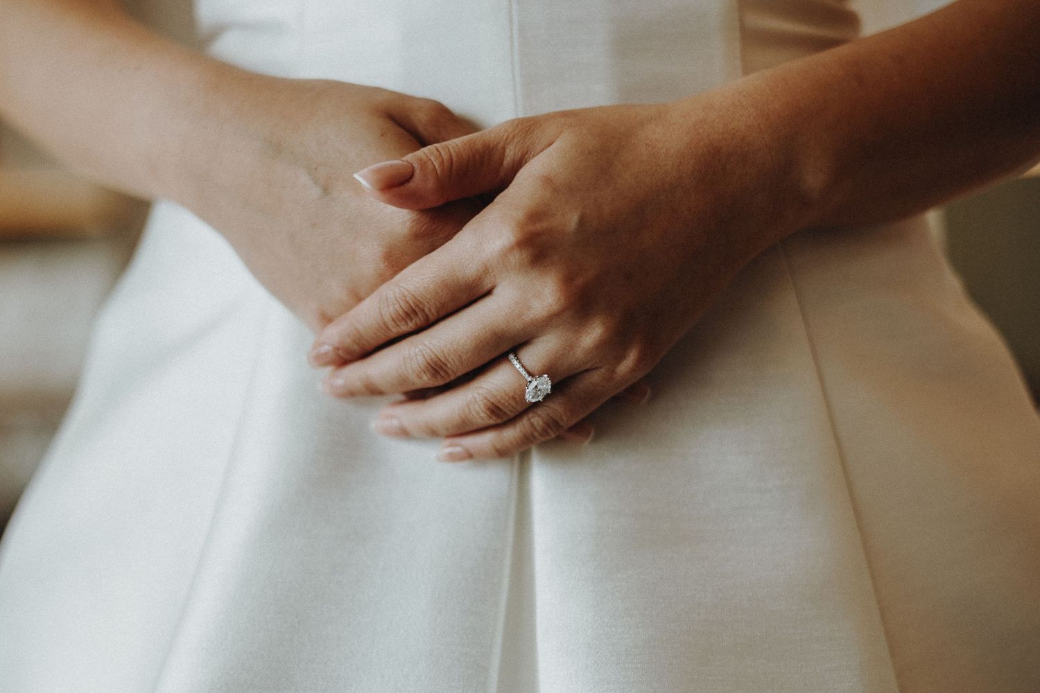 Close up detail shots of hands working with pristine white fabric material.