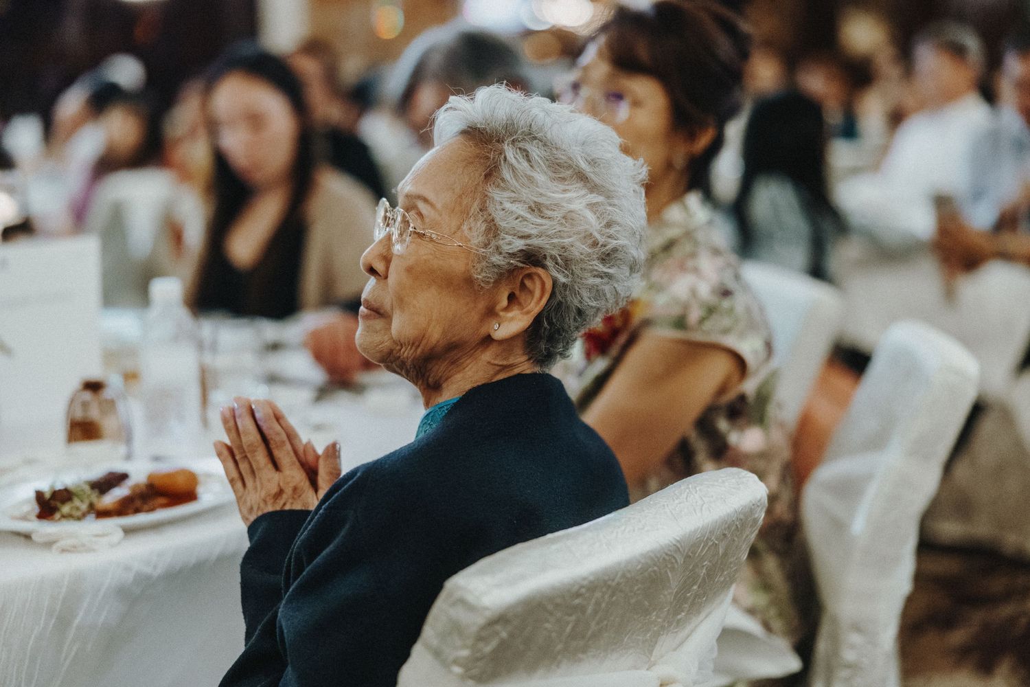 Wedding guests seated at reception tables during celebratory moments.