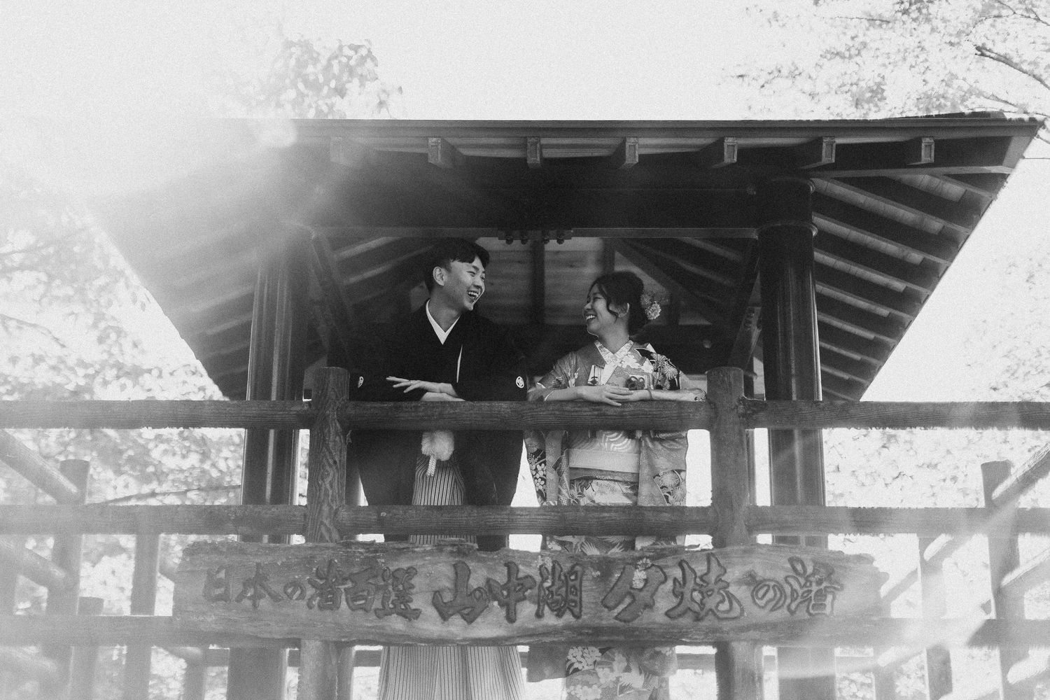 Rustic wooden pavilion structure with a traditional Asian architectural style and tiled roof design.