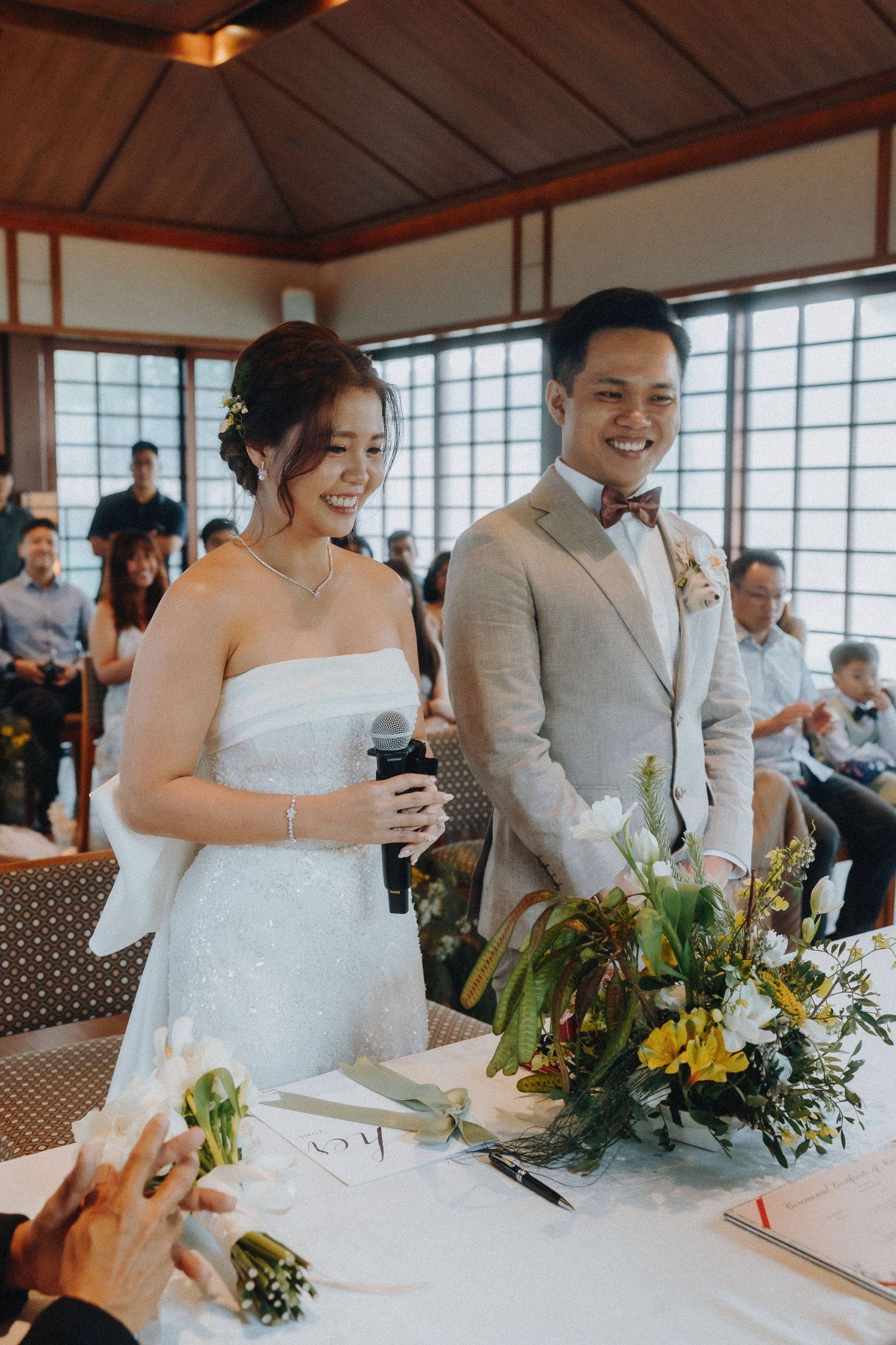 Wedding ceremony in traditional Japanese room with floral arrangements and decorative elements.