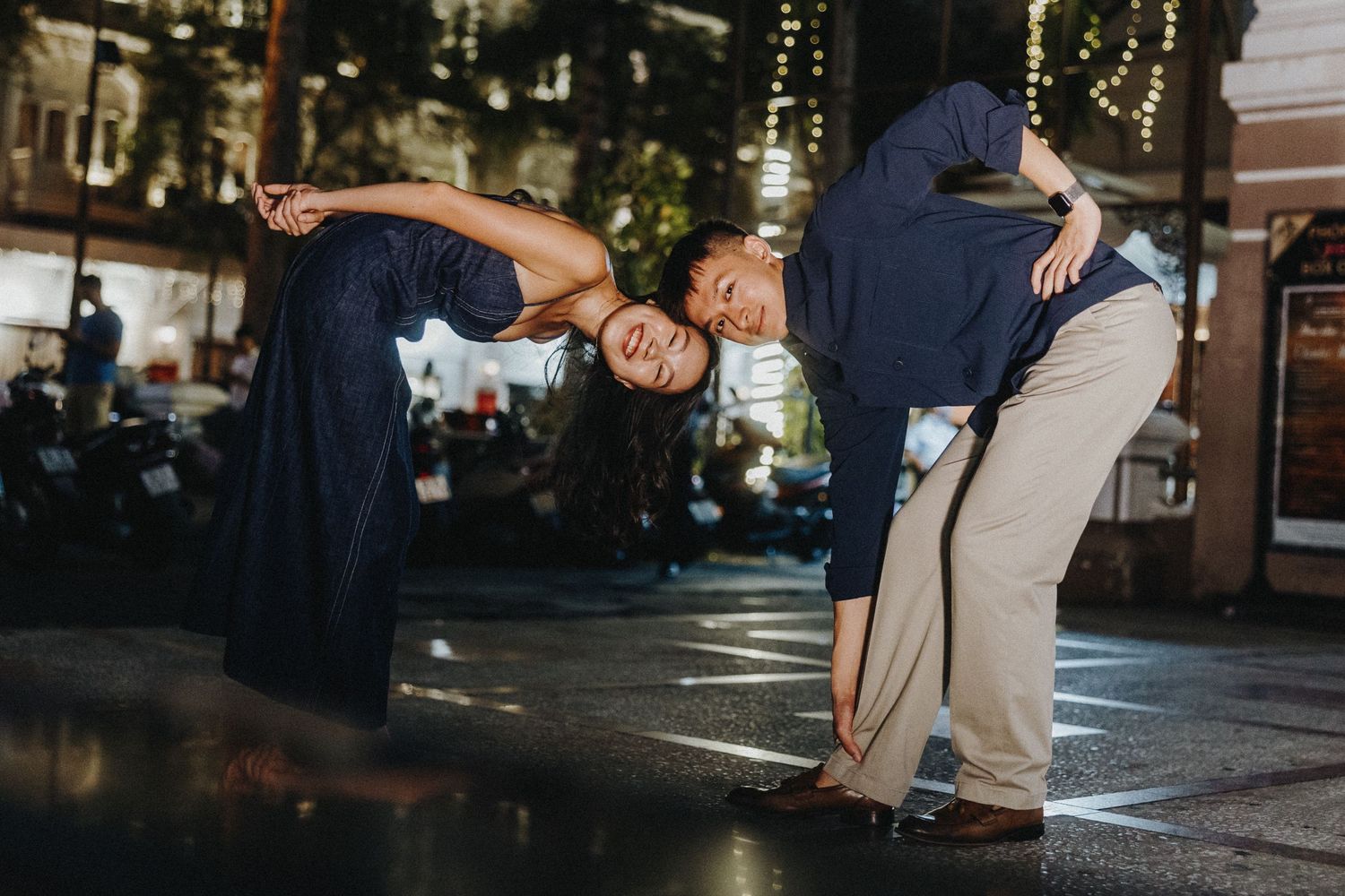Night photography sequence showing dance movements in silhouette against city lights and buildings.