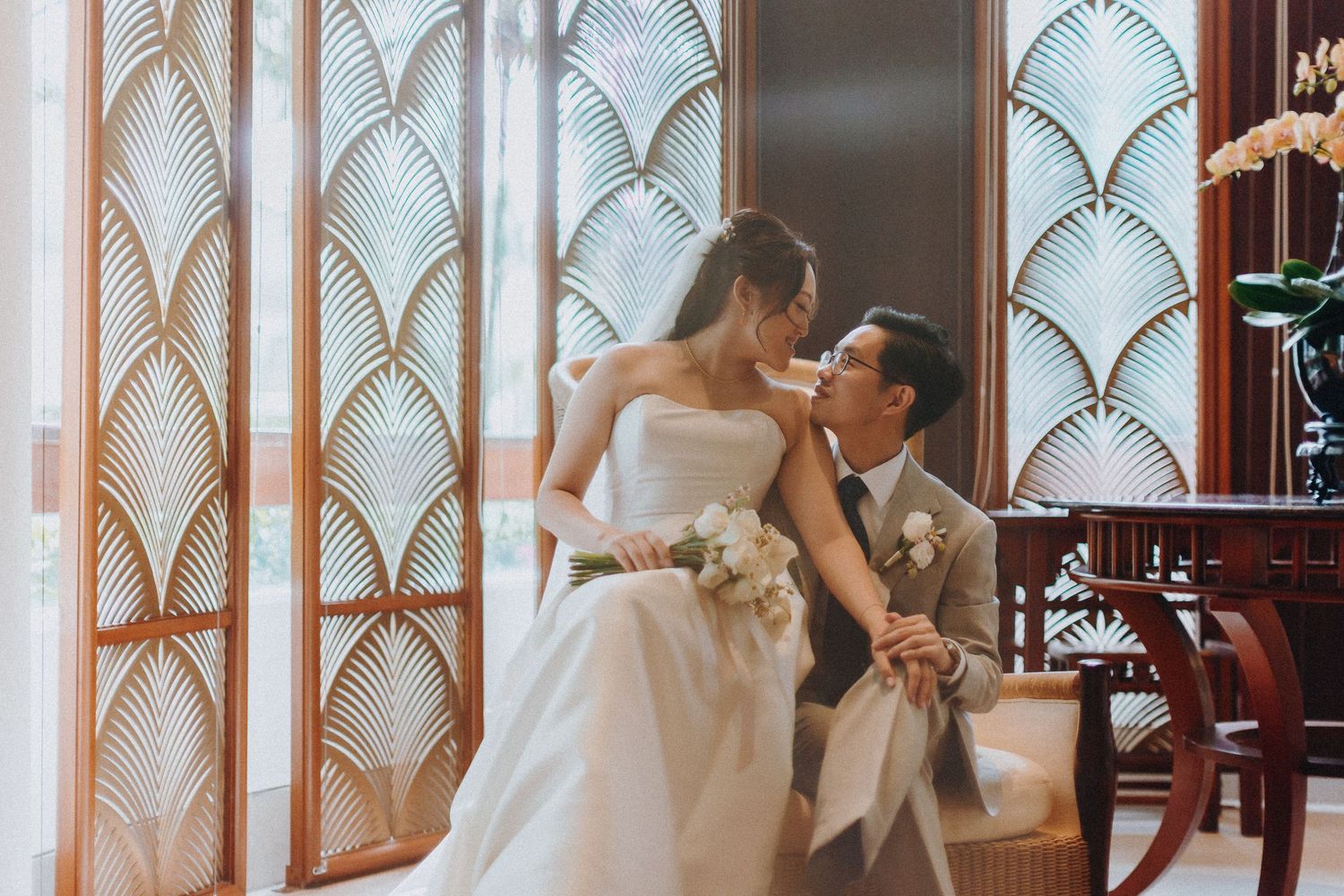 Romantic wedding moment in front of an art deco style backdrop with geometric patterns.