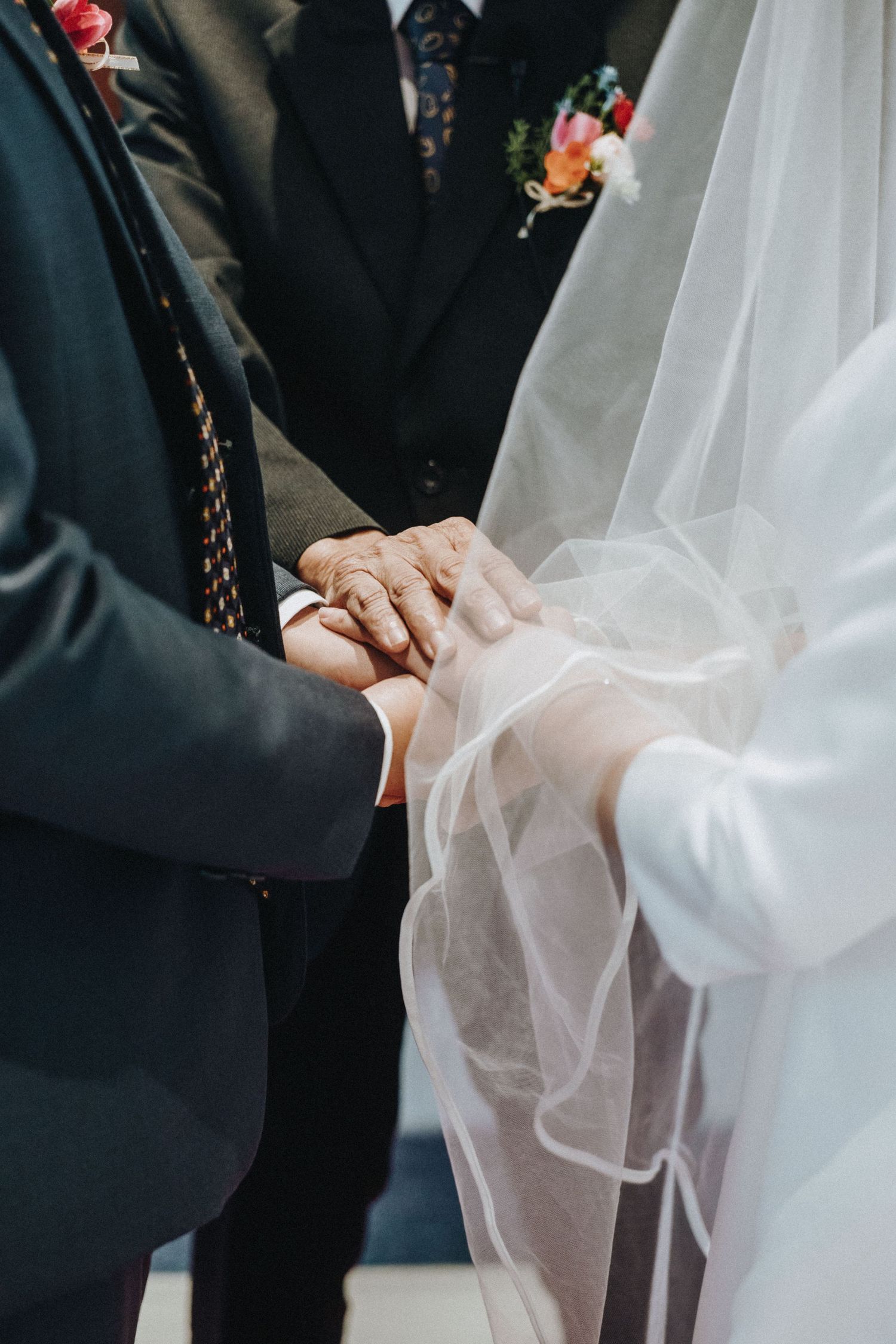Bride and groom exchanging rings during wedding ceremony, with officiant standing behind them.