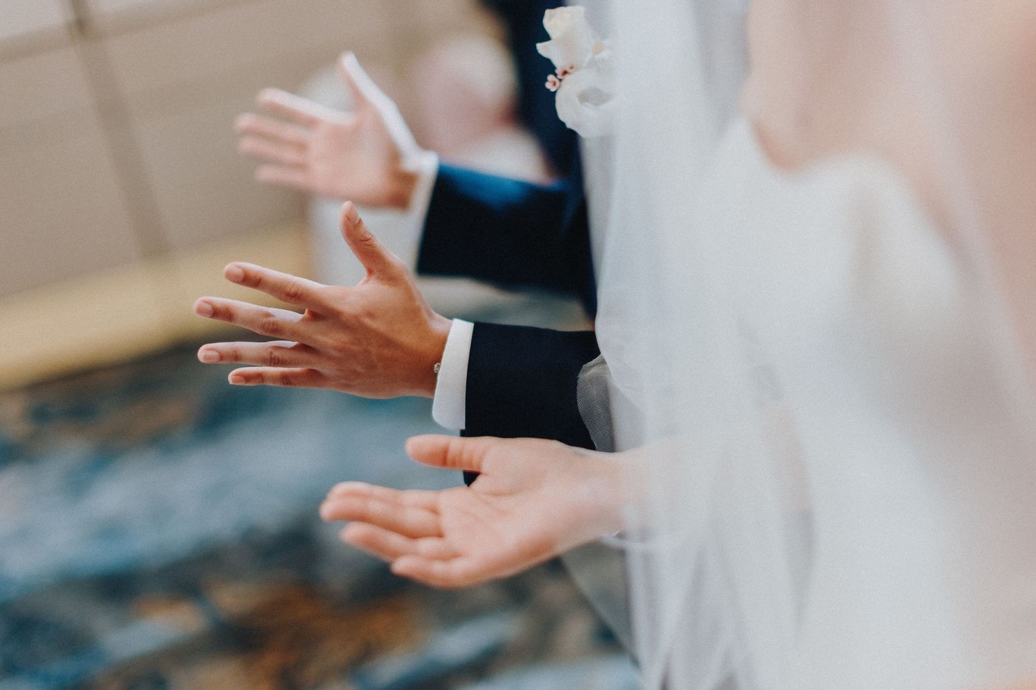 Wedding guests clap and cheer during a celebration in an elegant venue.