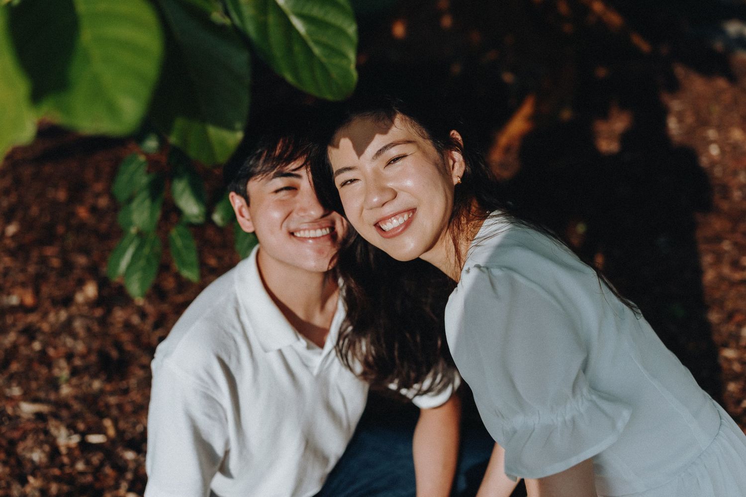 A candid moment of laughter and closeness shared between two people in casual attire.