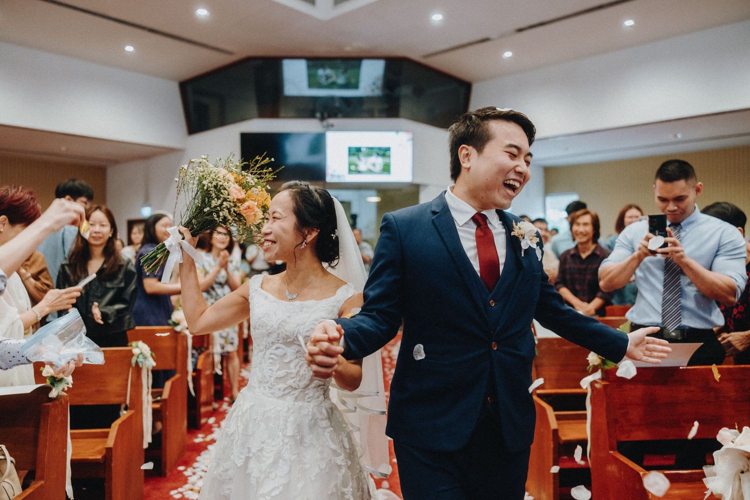 Joyful wedding celebration with laughter and candid moments in church setting.