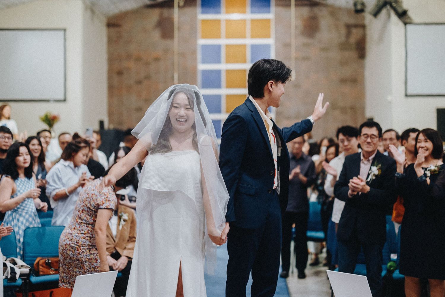 Joyful wedding ceremony with bride and groom celebrating in front of guests.
