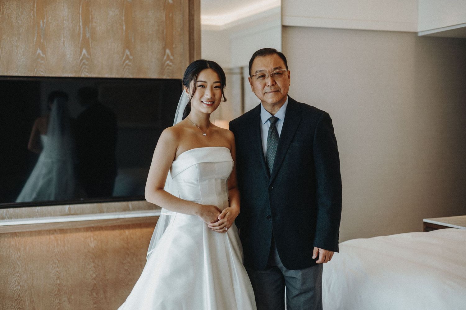 Couple in a modern hotel room sharing an intimate moment during their wedding photography session.