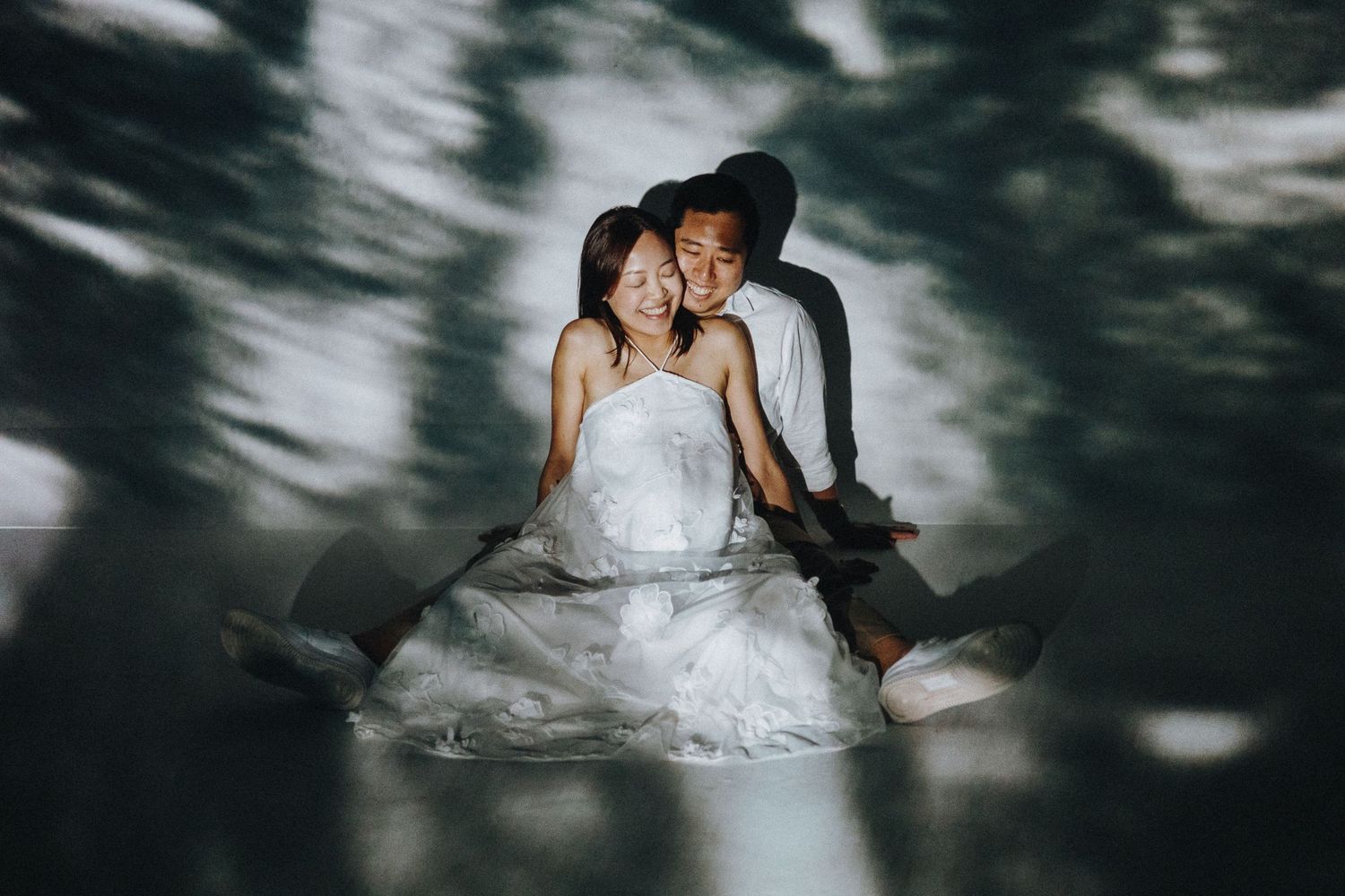 Dark and moody wedding photography with shadows cast across dancing and embracing couples.