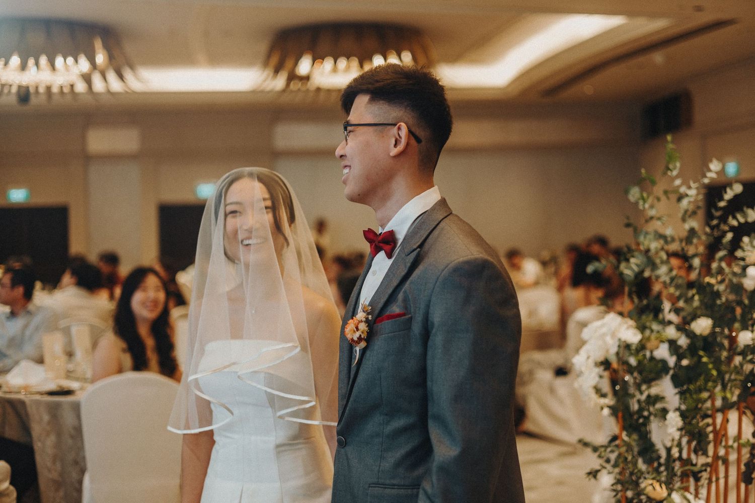 A couple during their wedding ceremony in an elegant hotel ballroom.