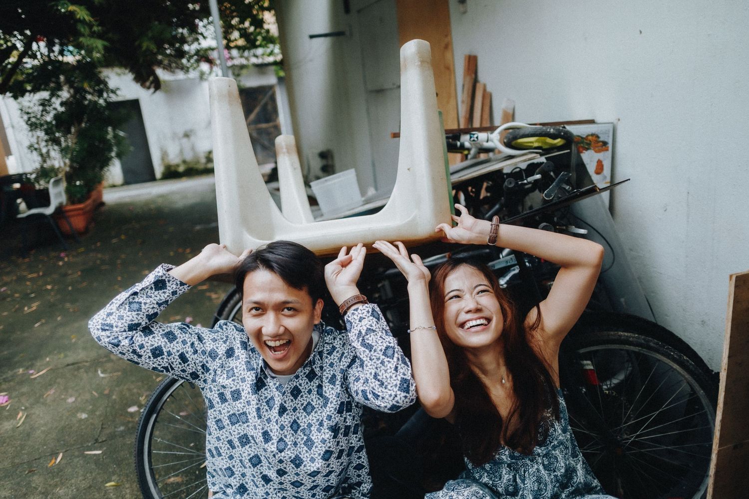 Couple shares candid laughing moments during a casual photoshoot outdoors.