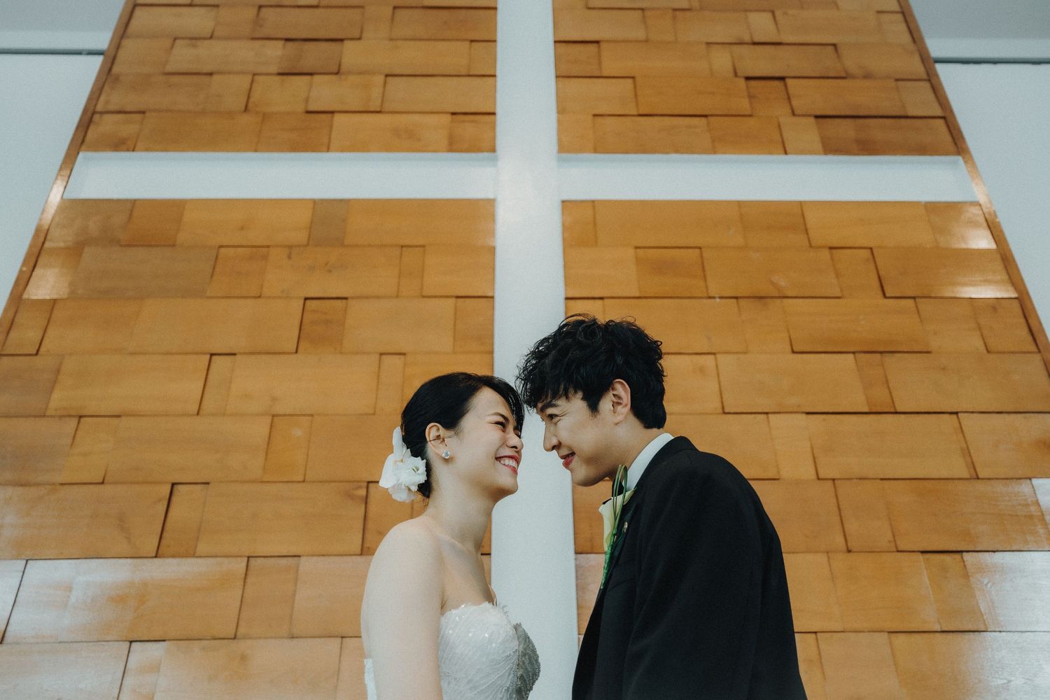 Modern reception venue with geometric wood paneled walls and bright lighting.