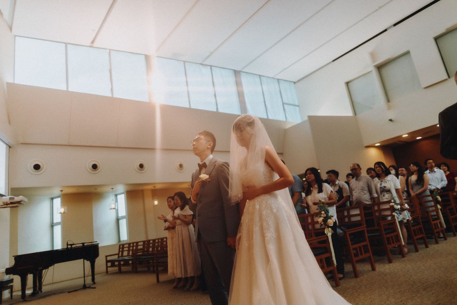Wedding celebration in a bright interior space with guests dancing and mingling.