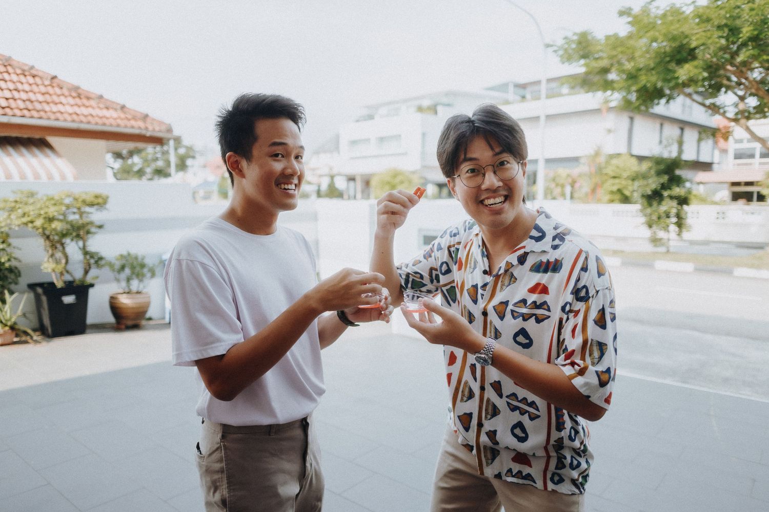 Two friends share a laugh while conversing together outdoors on a sunny day.