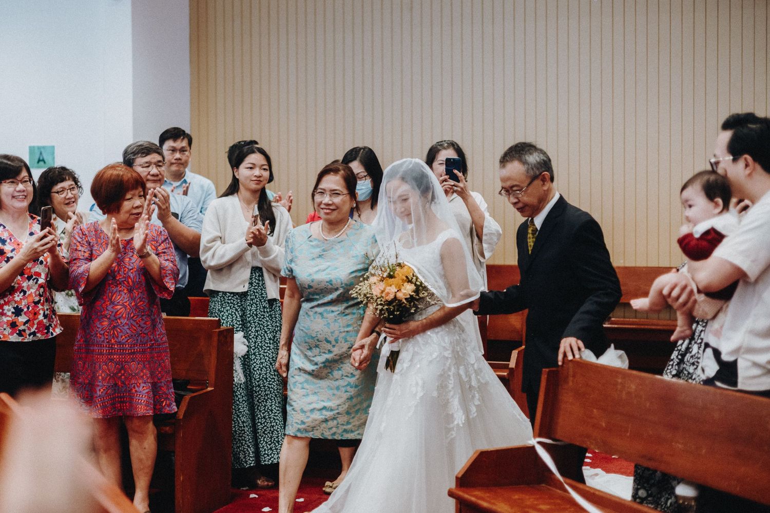 Wedding reception scene with guests celebrating and dancing in church hall.
