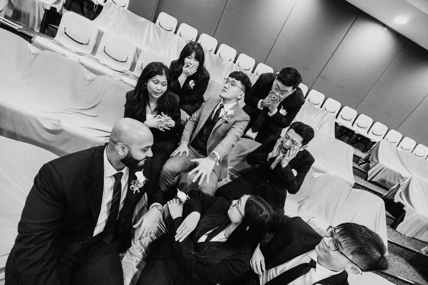 Wedding guests share joyful moments during a reception celebration in an indoor venue.
