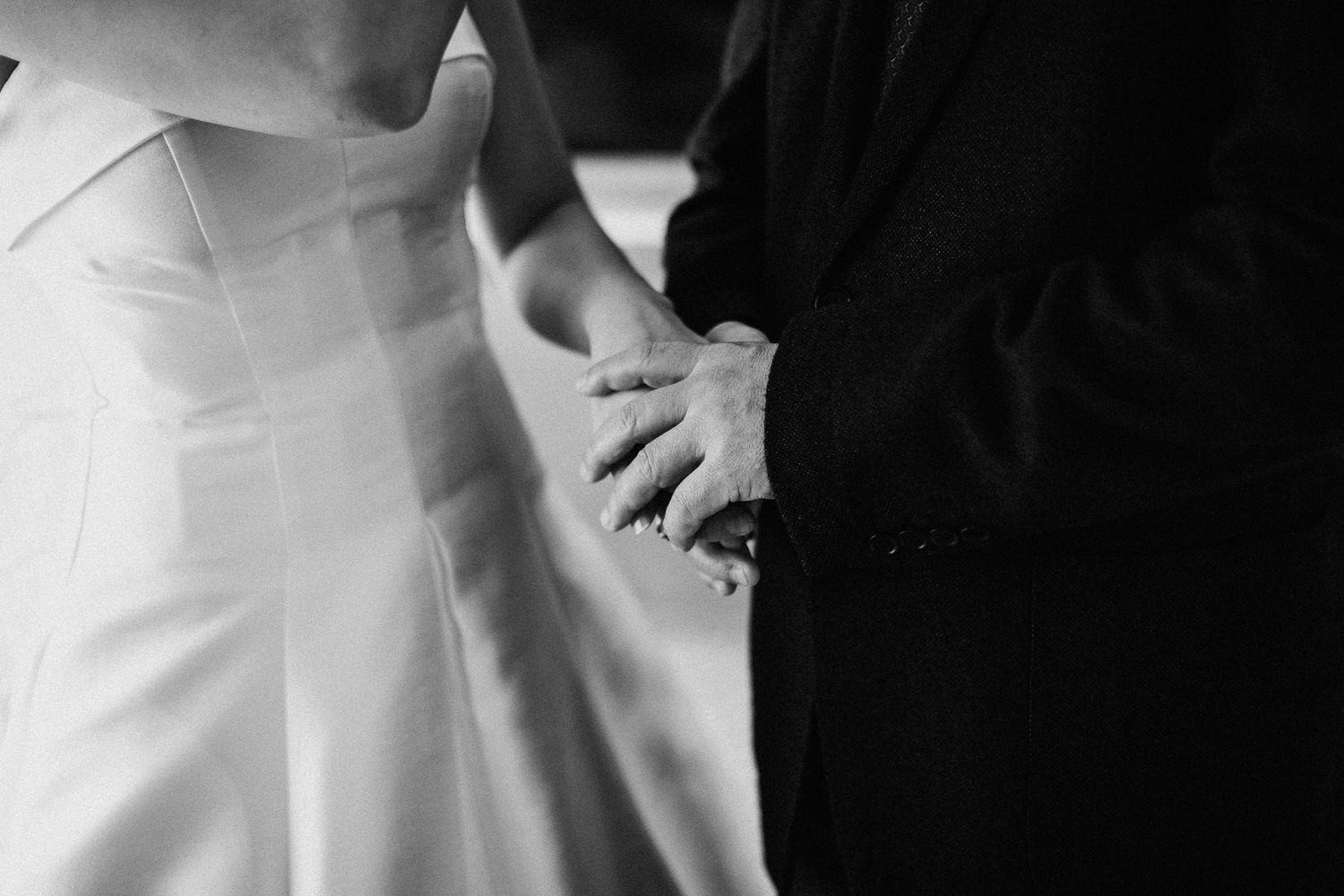Artistic black and white close-up of wedding dress details.