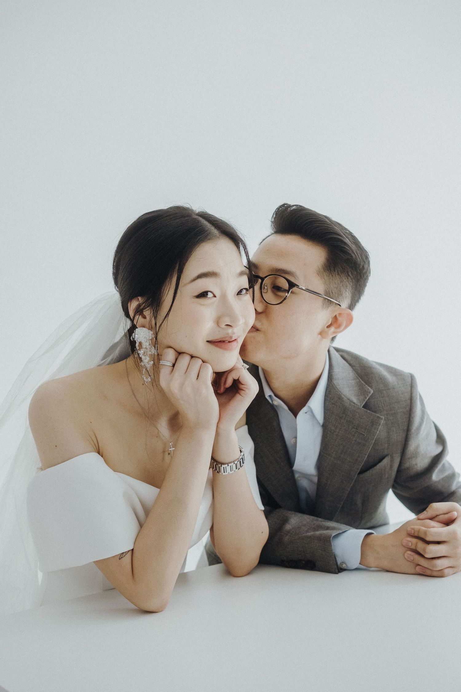 Intimate couple's photo shoot with white background showing playful and romantic poses.