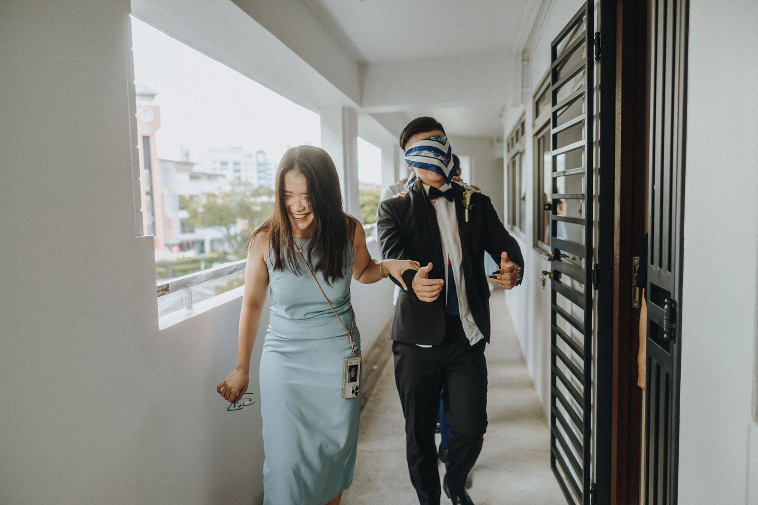 People walking down a bright white hallway in casual attire.