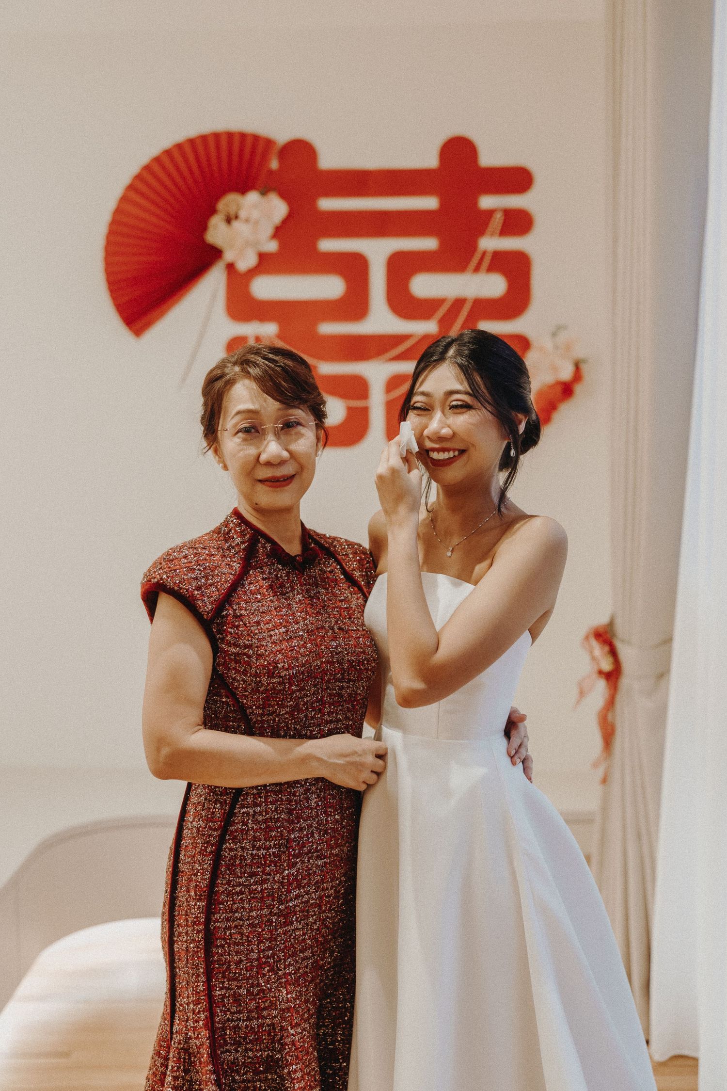 Wedding celebration featuring traditional red Chinese fans and contrasting red and white attire at an indoor venue.