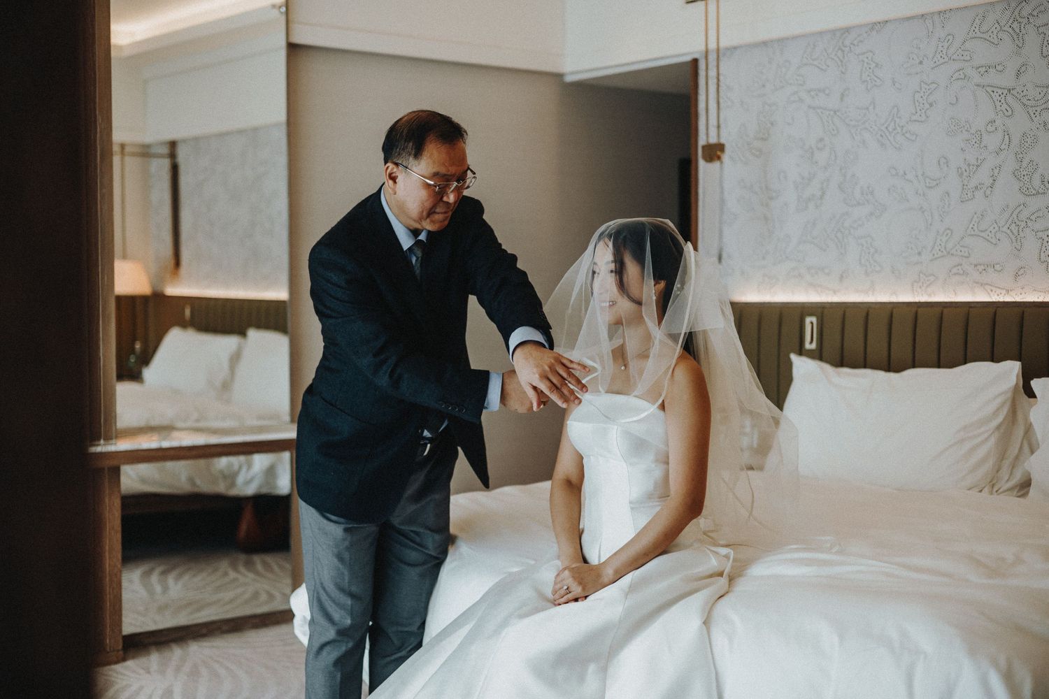 Wedding photography session featuring tender moments between newlyweds in a luxury hotel suite.