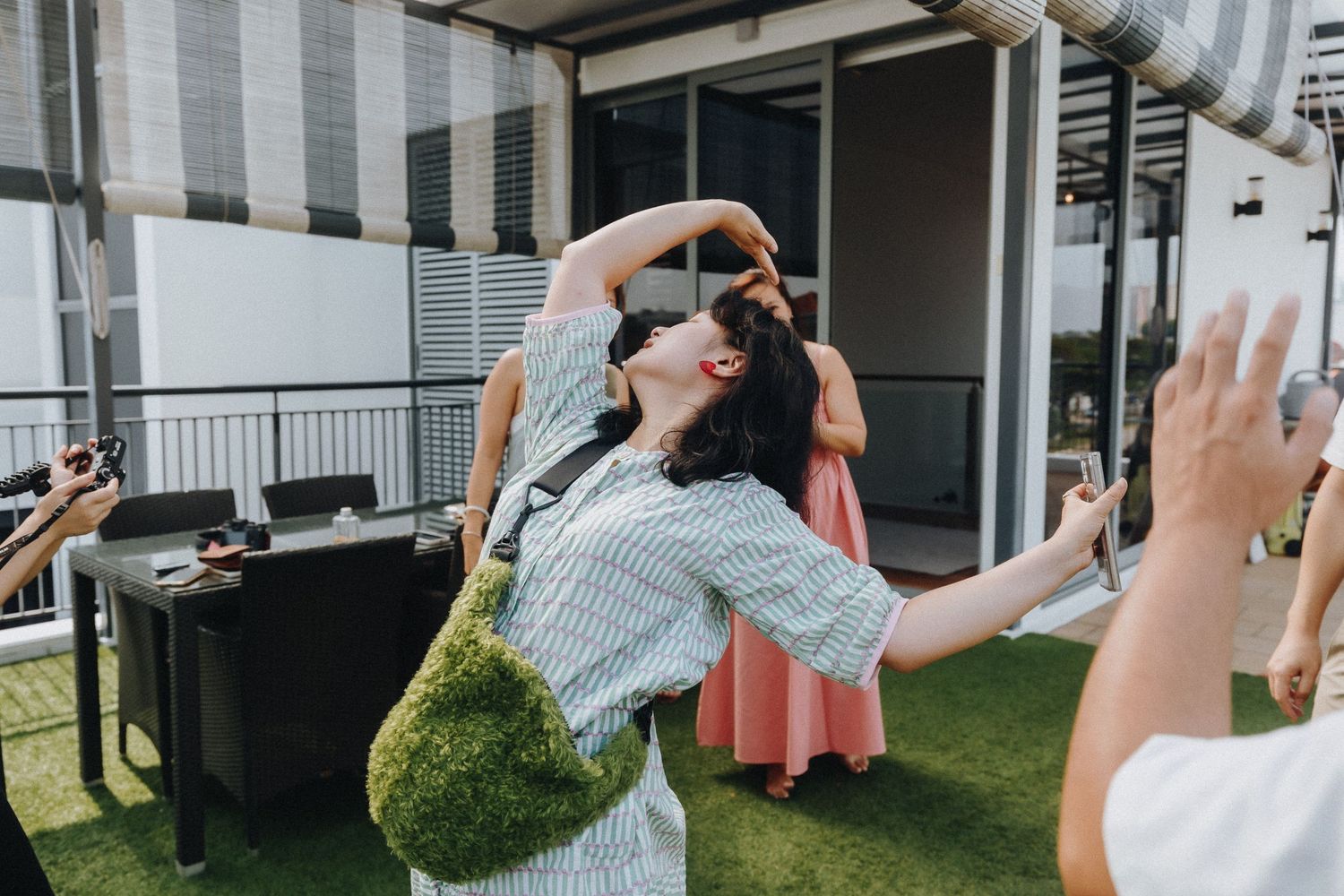A celebratory moment captured outdoors on a rooftop venue with joyful dancing and movement.