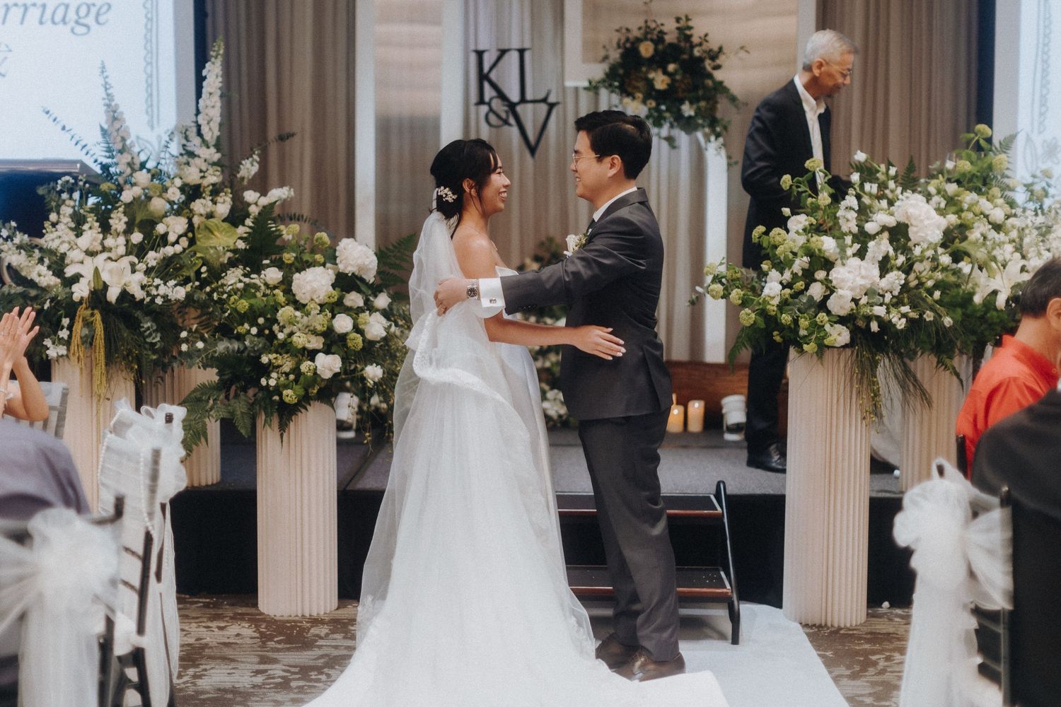 A series of black and white wedding reception photos showing couple dancing, with white floral decor and traditional elements.