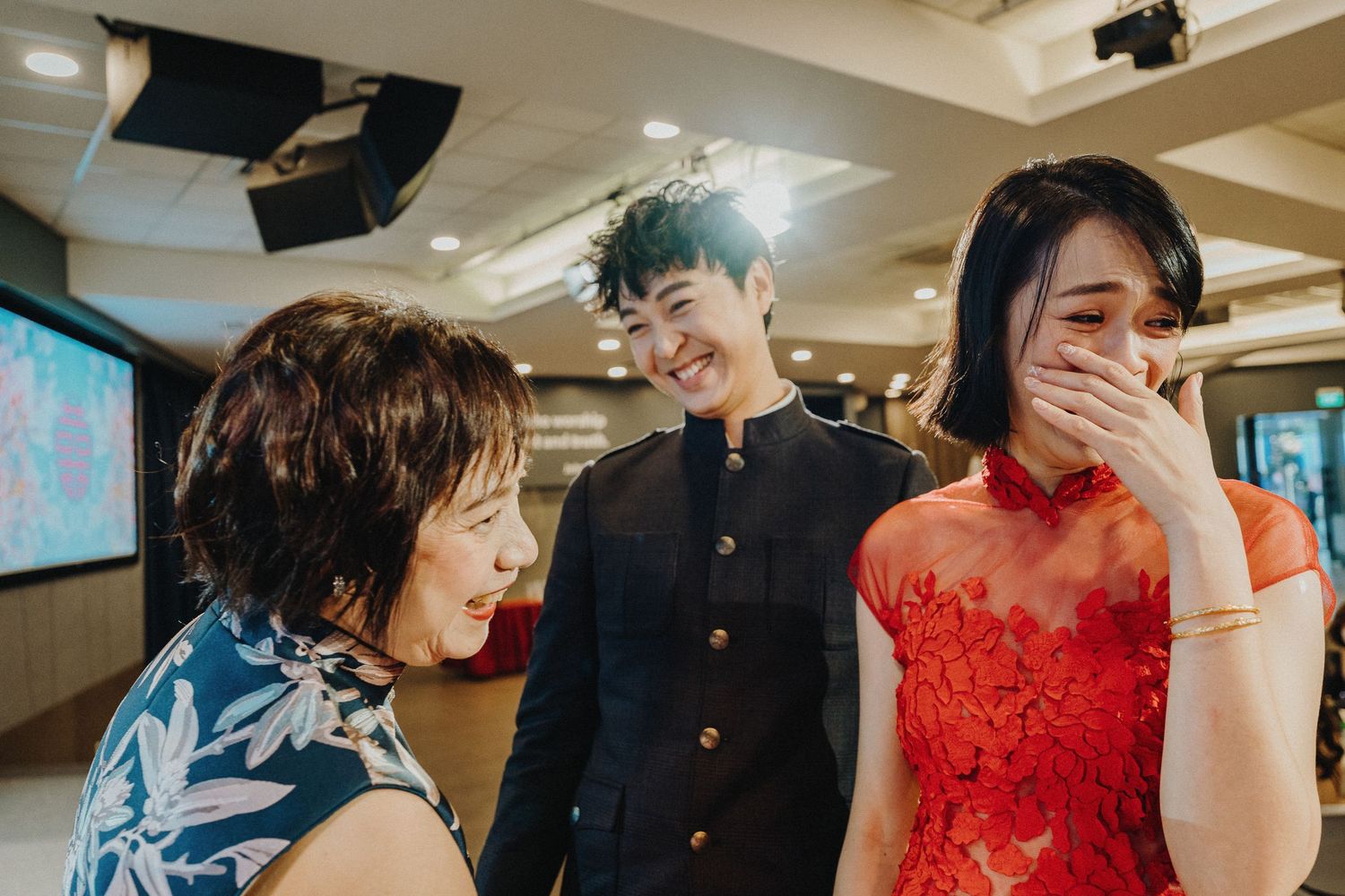 Wedding celebration with guests in formal attire and traditional red dress.