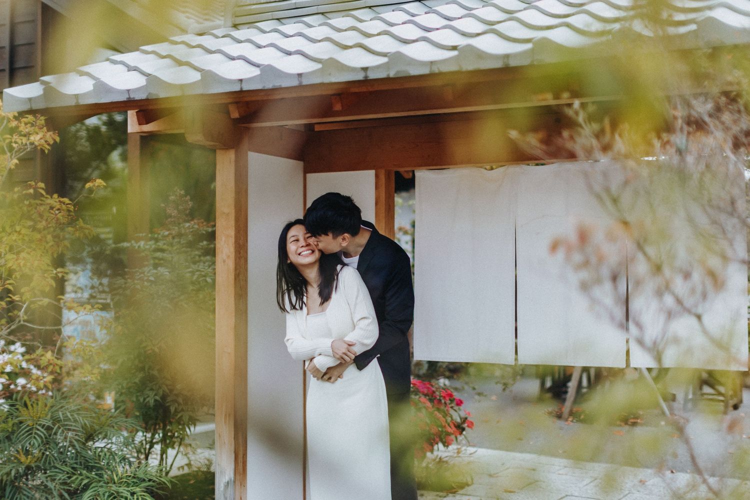 Wedding couple poses in an elegant Japanese tea house with soft natural lighting.